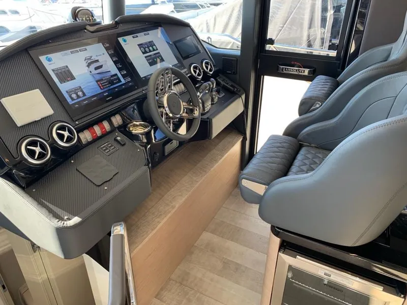Slide: The Image of 2024 Absolute 58 Navetta yacht helm station with advanced navigation systems and luxurious seating. - 19