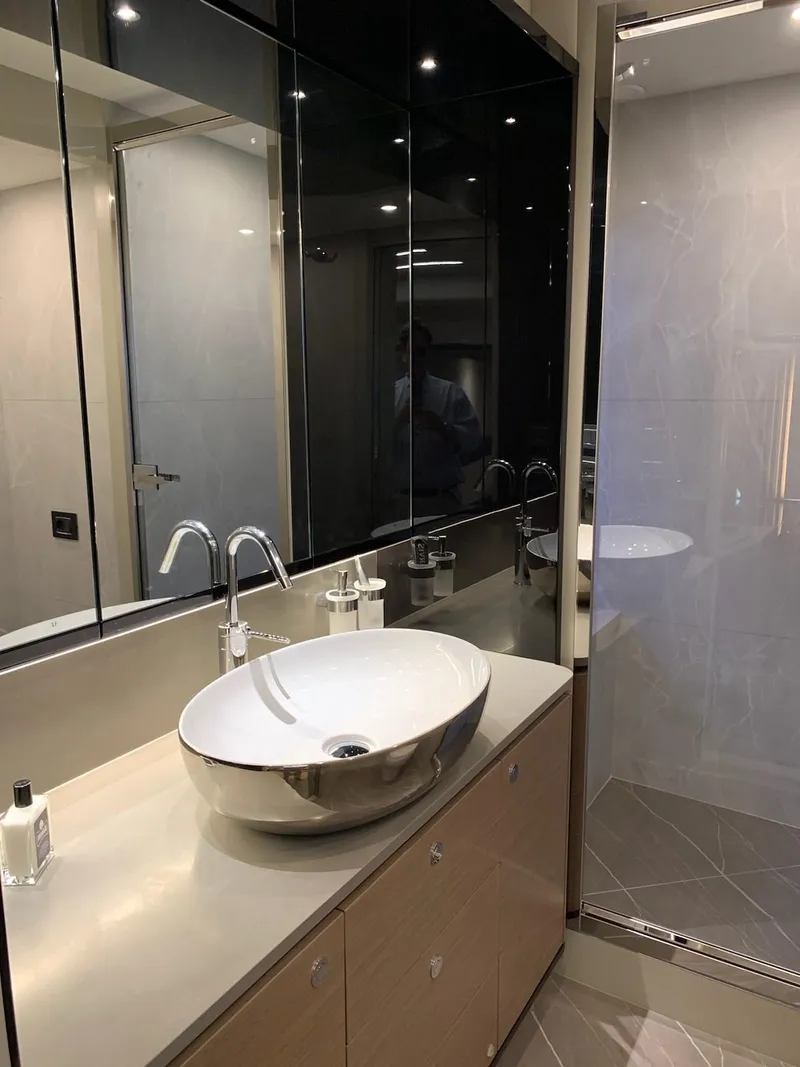 Slide: The Image of Modern bathroom in 2024 Absolute 58 Navetta yacht with sleek sink and mirrored cabinets. - 21