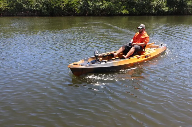 Slide: The Image of Man kayaking on a 2023 Old Town Sportsman Autopilot 136 in a calm river. - 22