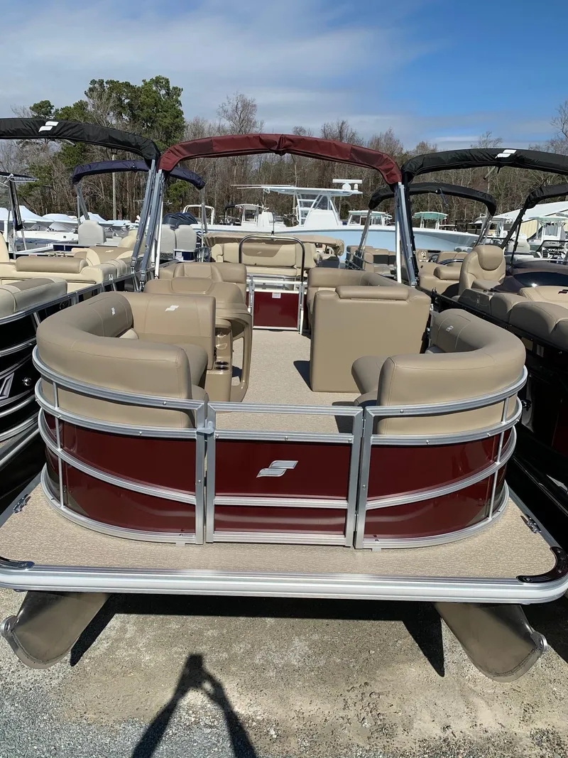 Slide: The Image of 2024 Starcraft LX20R pontoon boat with beige seating and red exterior. - 2