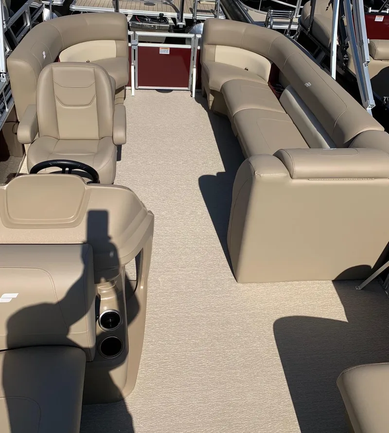 Slide: The Image of 2024 Starcraft LX20R pontoon boat interior with beige seating and steering console. - 8
