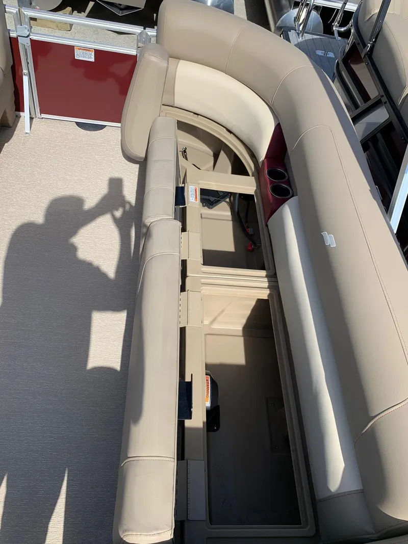 Slide: The Image of 2024 Starcraft LX20R boat with open storage compartments and beige seating. - 12