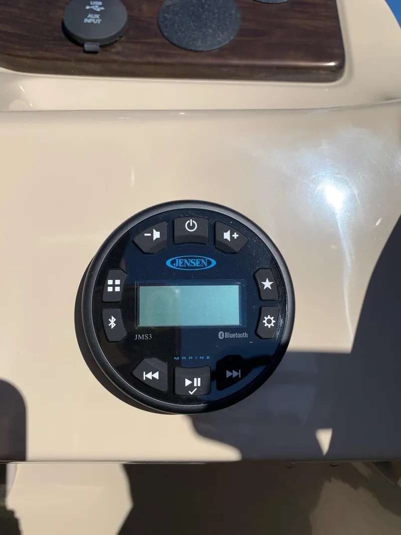 Slide: The Image of 2024 Starcraft EX22Q boat dashboard with Jensen audio system. - 16