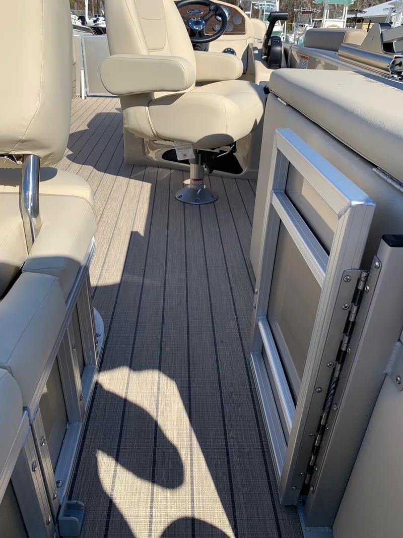 Slide: The Image of 2024 Starcraft EX22Q boat interior with beige seating and deck. - 5