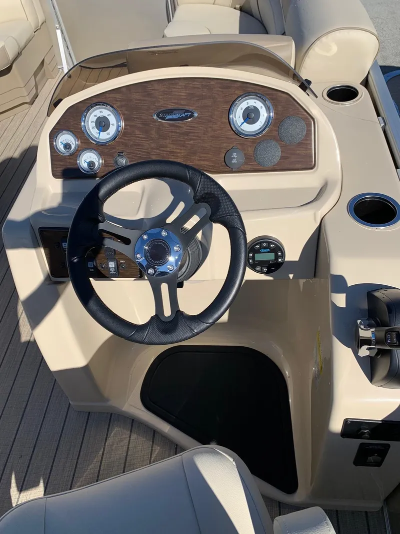 Slide: The Image of 2024 Starcraft EX22Q boat dashboard with steering wheel and control panel. - 9