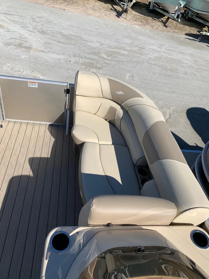 Slide: The Image of 2024 Starcraft EX22Q pontoon boat with beige seating and cup holders. - 10