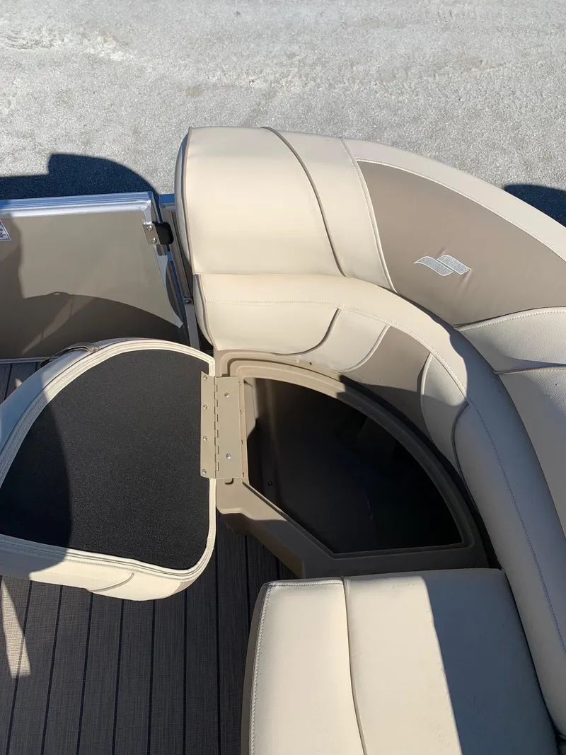 Slide: The Image of 2024 Starcraft EX22Q boat with open storage compartment and beige seating. - 12