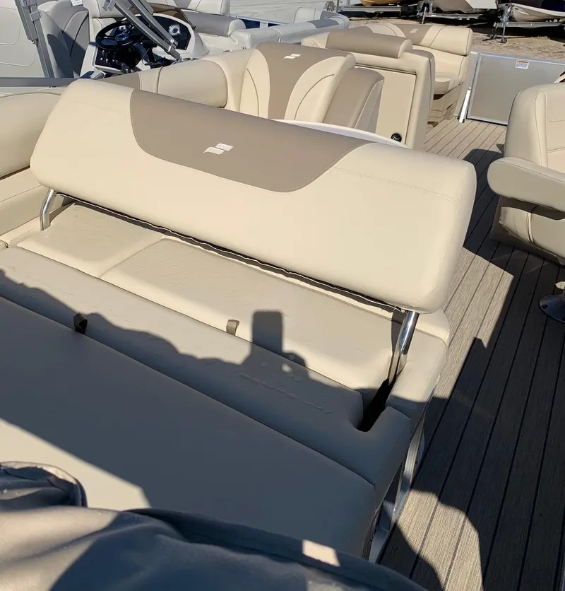 Slide: The Image of 2024 Starcraft EX22Q boat interior with beige seating and steering console. - 4