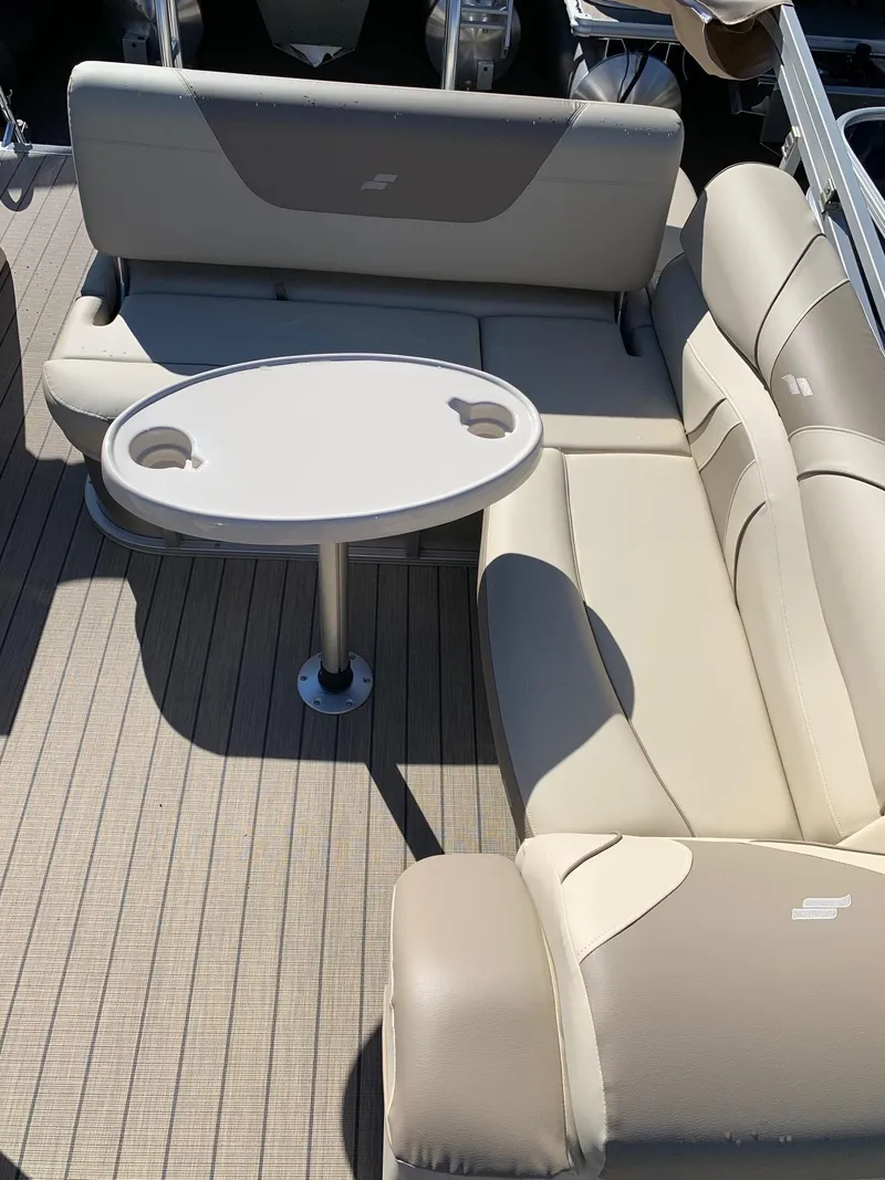 Slide: The Image of 2024 Starcraft EX22Q boat interior with beige seating and oval table. - 7