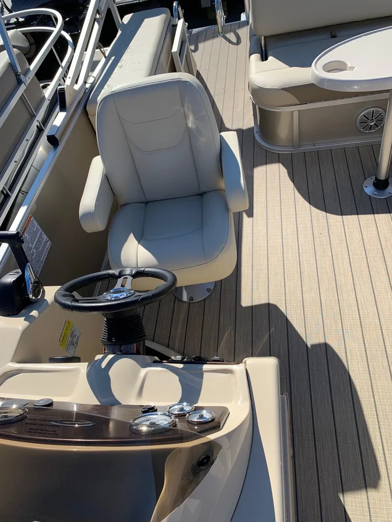 Slide: The Image of 2024 Starcraft EX22Q boat interior with captain's chair and steering wheel. - 8