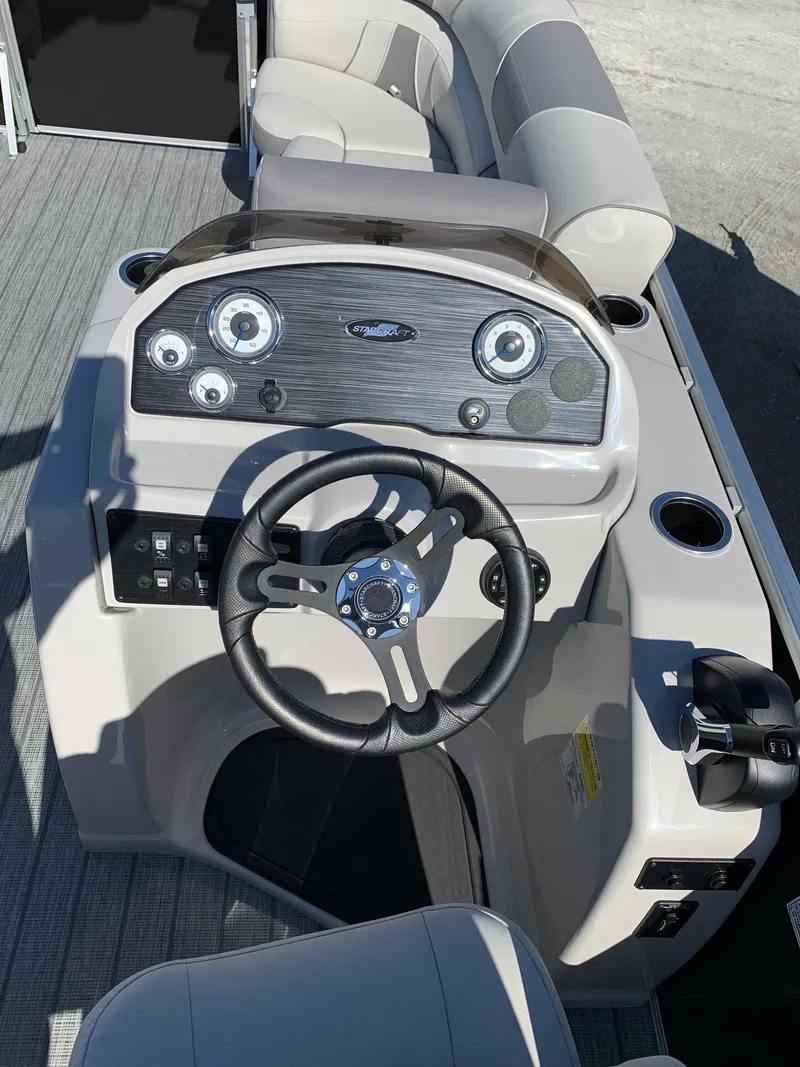 Slide: The Image of 2024 Starcraft EX22Q boat dashboard with steering wheel and control panel. - 11