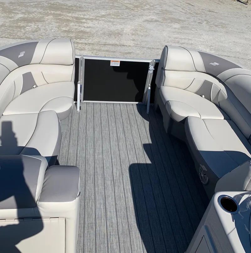 Slide: The Image of 2024 Starcraft EX22Q pontoon boat interior with plush seating and gray flooring. - 7
