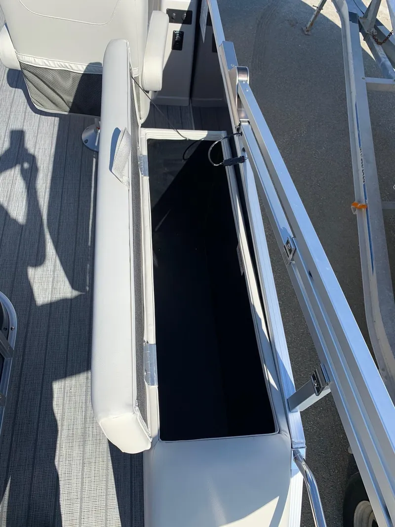 Slide: The Image of 2024 Starcraft EX22Q boat with open storage compartment. - 14