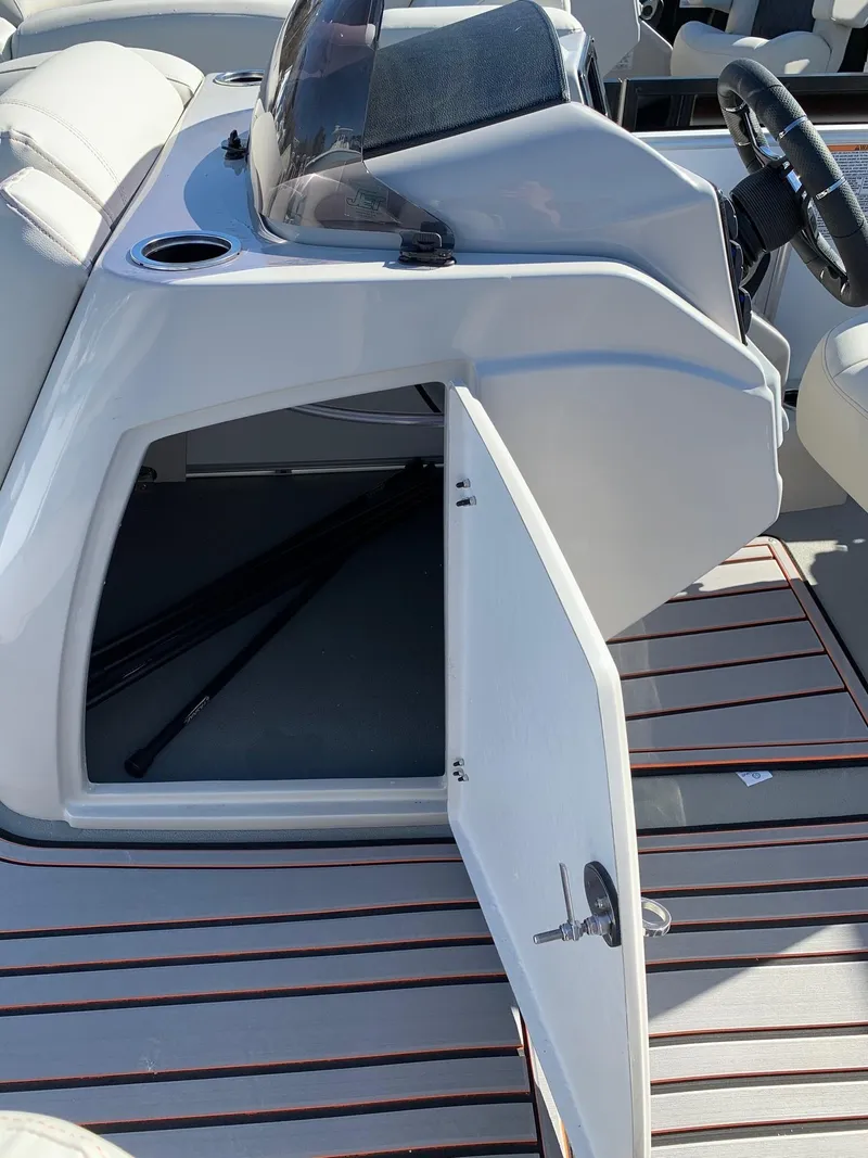 Slide: The Image of 2024 Starcraft SLS3 boat with open storage compartment and modern dashboard. - 11