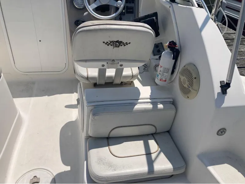 Slide: The Image of 2004 Wellcraft 252 Coastal boat cockpit with white seating and steering wheel. - 11