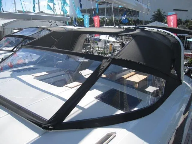 Slide: The Image of 2025 Jeanneau Yacht 65 with sleek black canopy at a marina. - 33