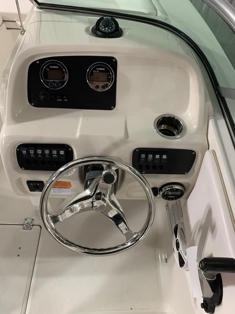 Slide: The Image of 2024 Robalo R207 Dual Console boat dashboard with steering wheel and control panel. - 7