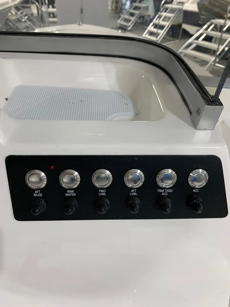 Slide: The Image of Control panel of 2024 Robalo 206 Cayman boat with various switches. - 13