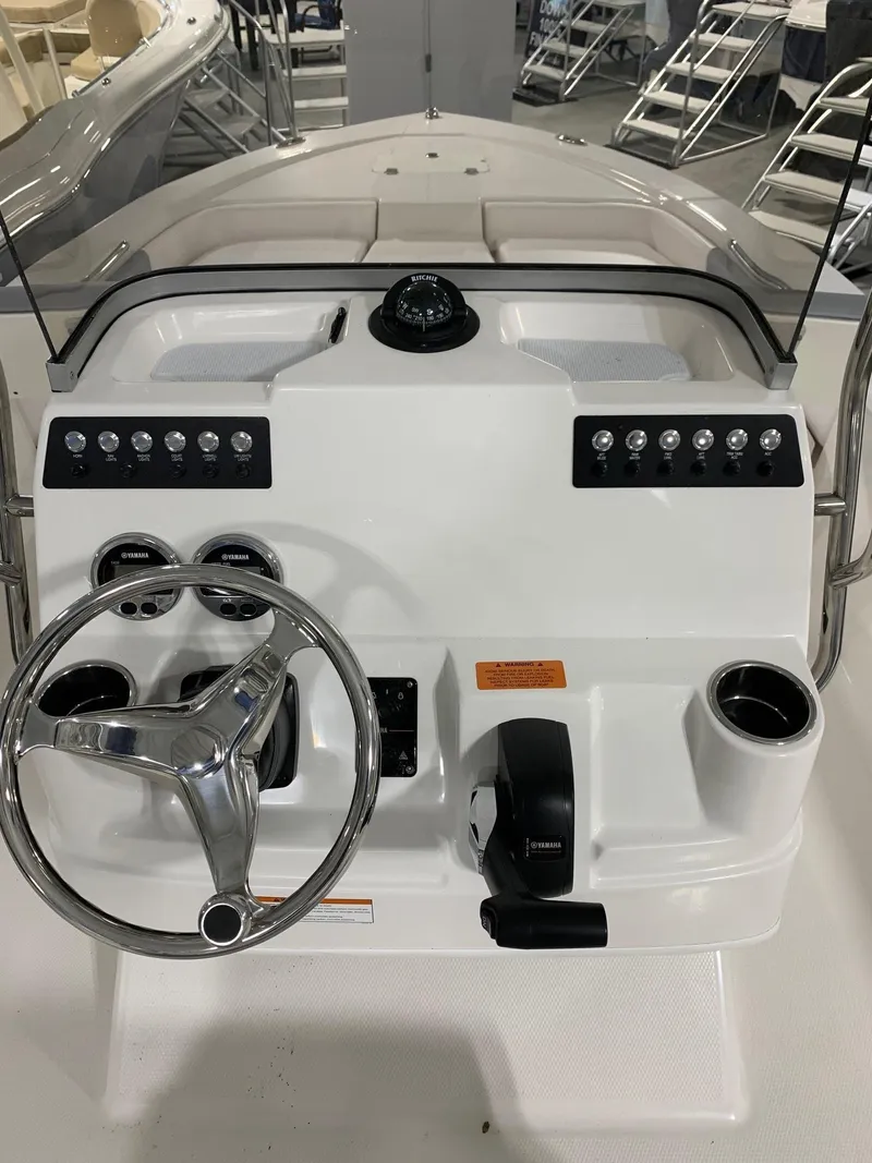 Slide: The Image of 2024 Robalo 206 Cayman boat dashboard with steering wheel and controls. - 15