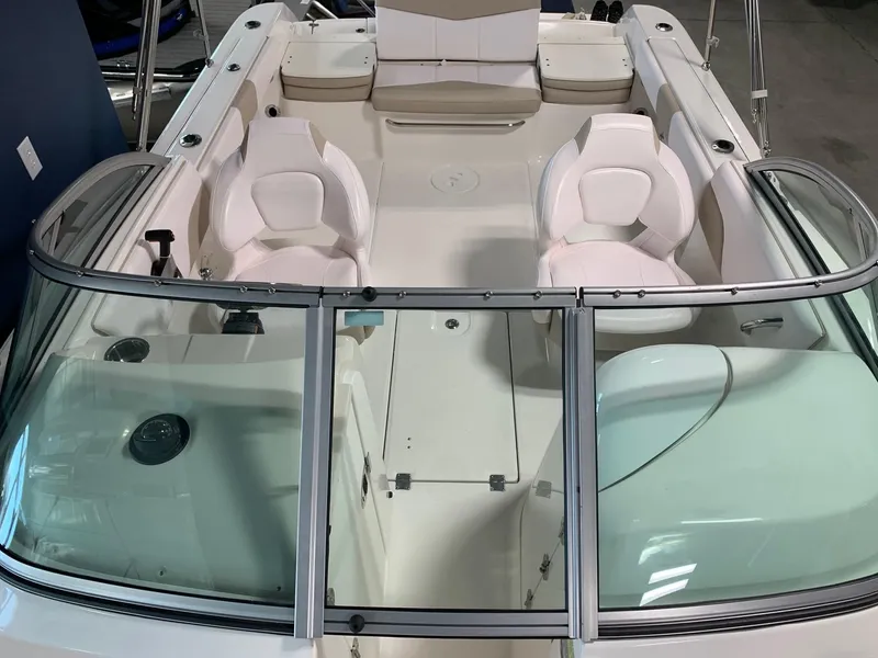 Slide: The Image of 2024 Robalo R207 Dual Console boat interior with white seating and windshield. - 10