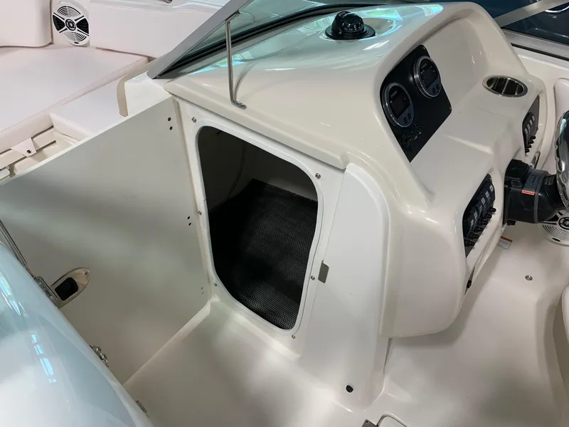 Slide: The Image of 2024 Robalo R207 Dual Console boat interior, showing storage compartment and dashboard. - 15