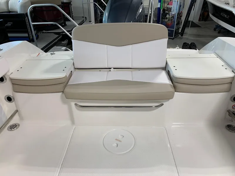 Slide: The Image of 2024 Robalo R207 Dual Console boat seating area with beige and white cushions. - 16