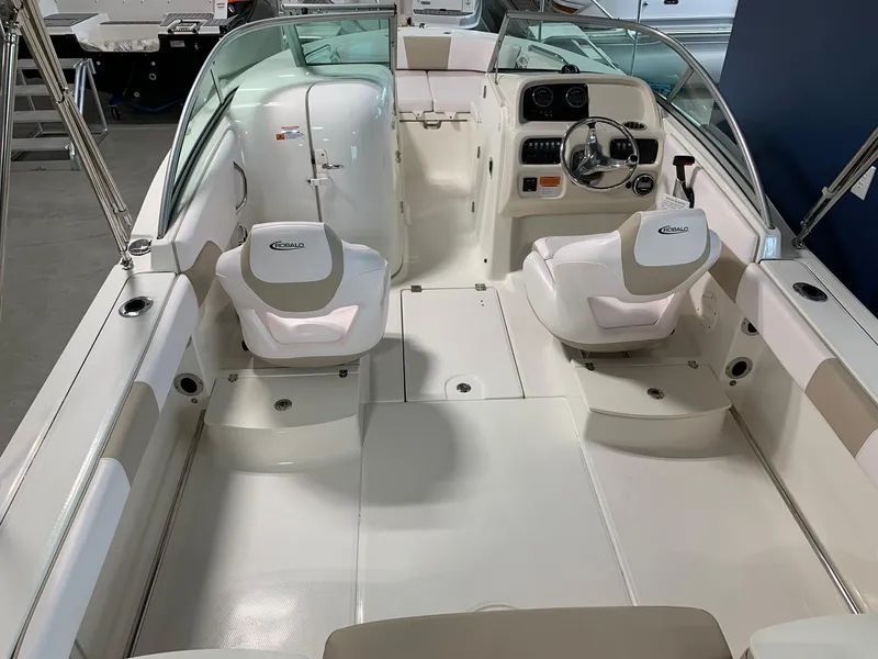 Slide: The Image of 2024 Robalo R207 Dual Console boat interior with white seating and steering console. - 4