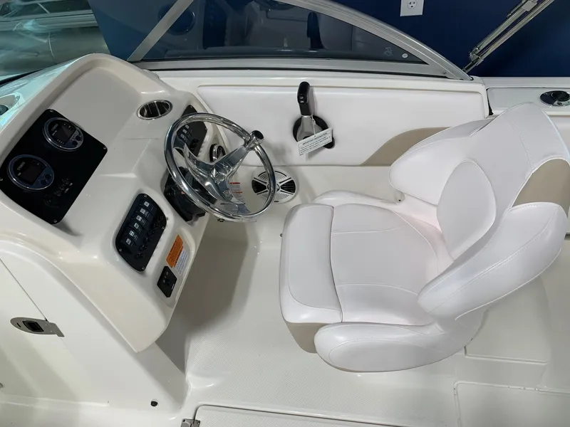Slide: The Image of 2024 Robalo R207 Dual Console boat cockpit with steering wheel and white captain's chair. - 10