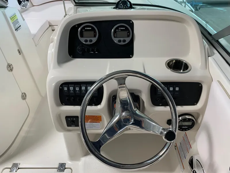 Slide: The Image of 2024 Robalo R207 Dual Console boat dashboard with steering wheel and gauges. - 11