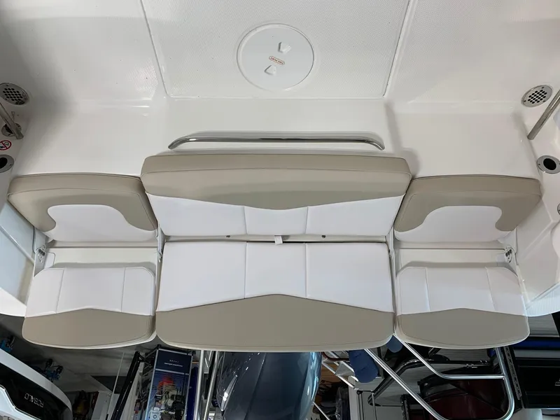 Slide: The Image of 2024 Robalo R207 Dual Console boat seating area with beige and white cushions. - 17