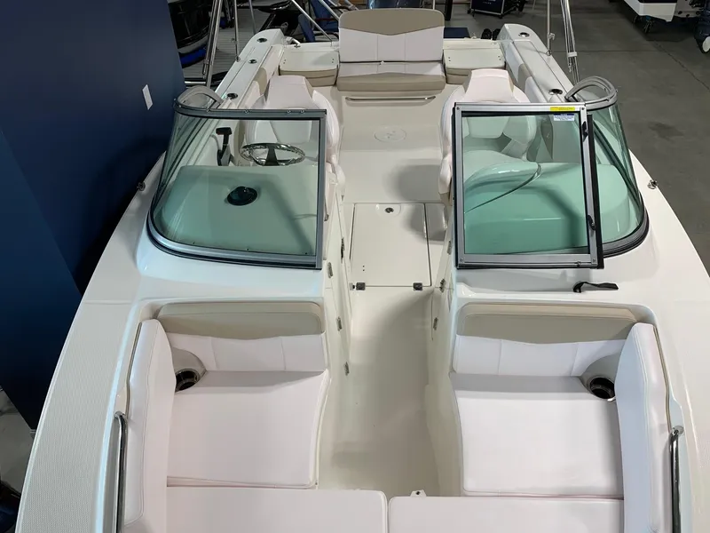 Slide: The Image of 2024 Robalo R207 Dual Console boat interior with white seating and dual windshields. - 6