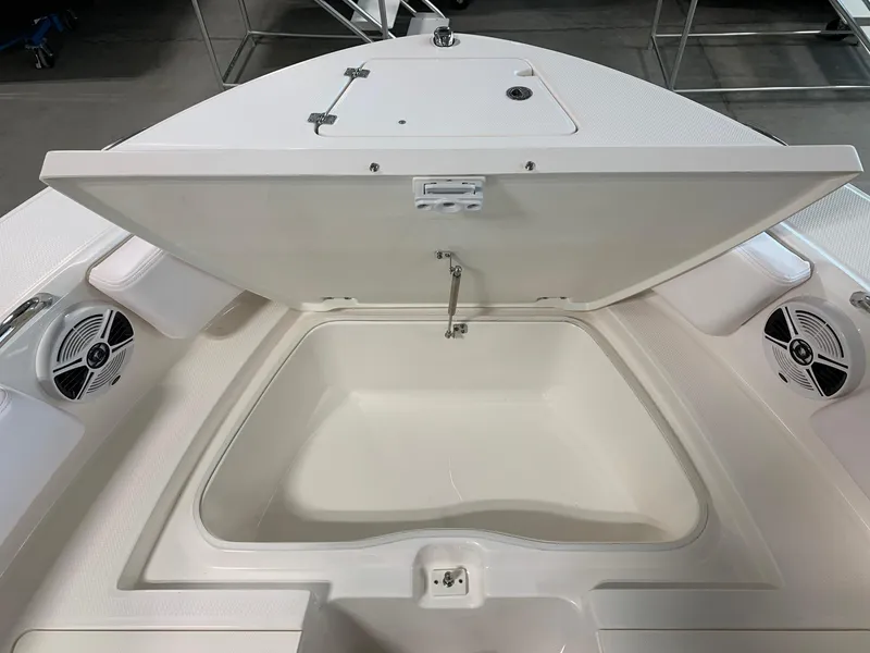 Slide: The Image of 2024 Robalo R207 Dual Console boat storage compartment with open lid. - 8
