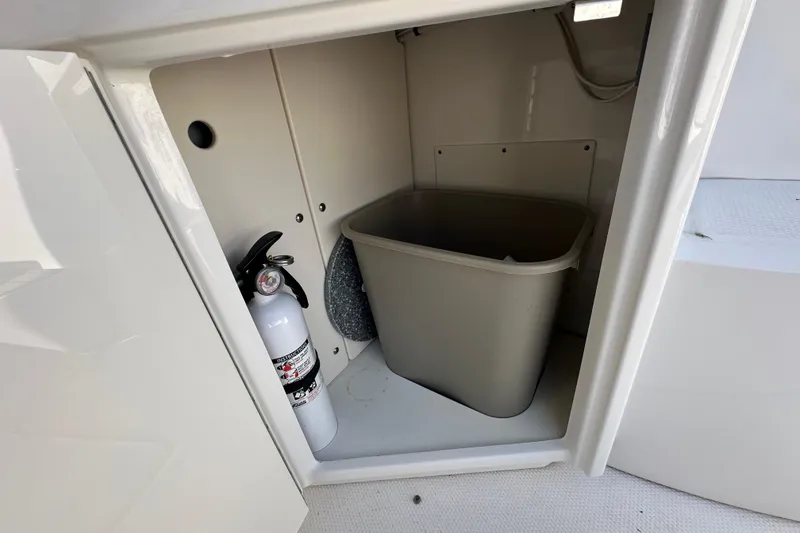 Slide: The Image of Storage compartment in 2019 Chaparral 347 SSX with fire extinguisher and trash bin. - 10