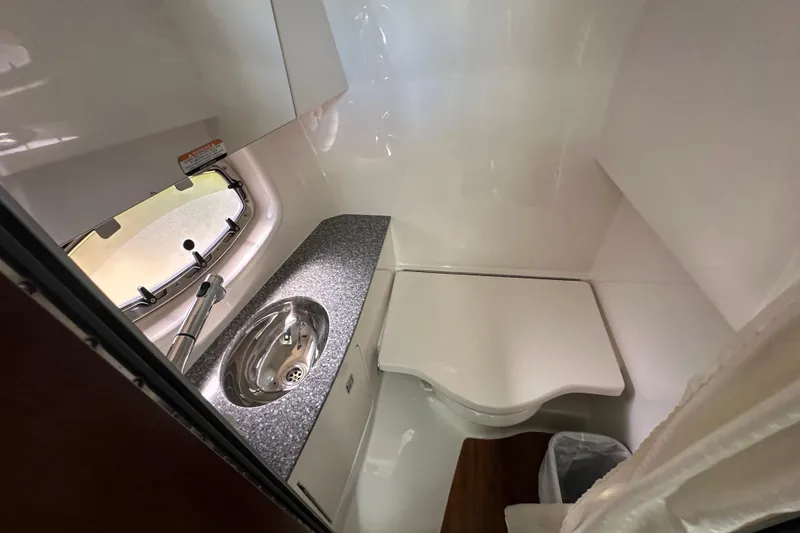 Slide: The Image of 2019 Chaparral 347 SSX boat bathroom with sink, countertop, and window. - 25