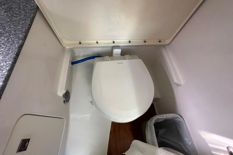 Slide: The Image of 2019 Chaparral 347 SSX boat bathroom with toilet and trash bin. - 26