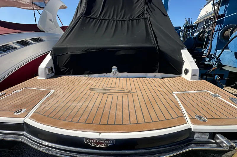 Slide: The Image of 2019 Chaparral 347 SSX boat with teak deck and black cover, docked at marina. - 5