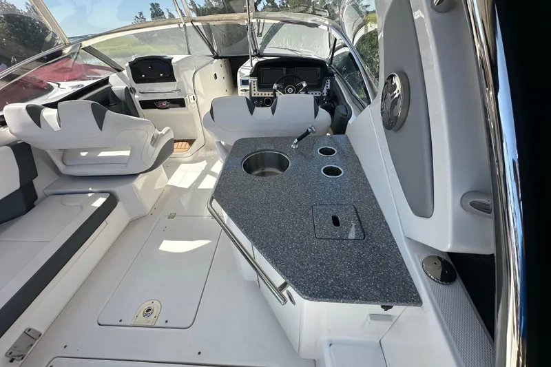 Slide: The Image of 2019 Chaparral 347 SSX boat interior with helm, seating, and kitchenette area. - 8