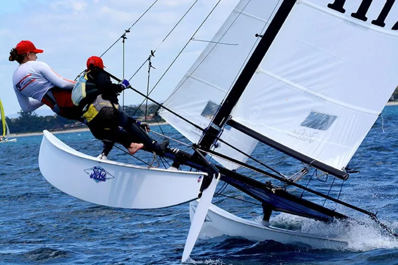 Slide: The Image of Two sailors on a 2023 Hobie Cat H16 catamaran sailing on open water. - 3