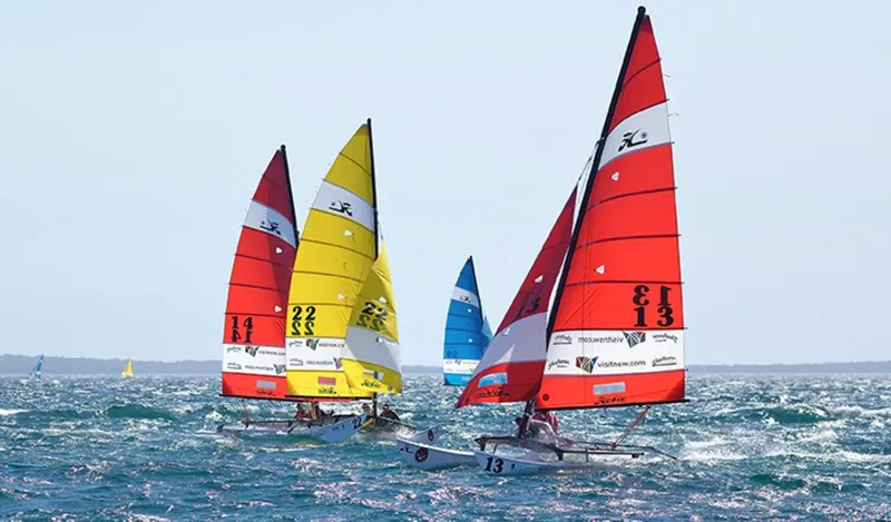 Slide: The Image of Colorful Hobie Cat H16 sailboats racing on the ocean, 2023 model. - 5