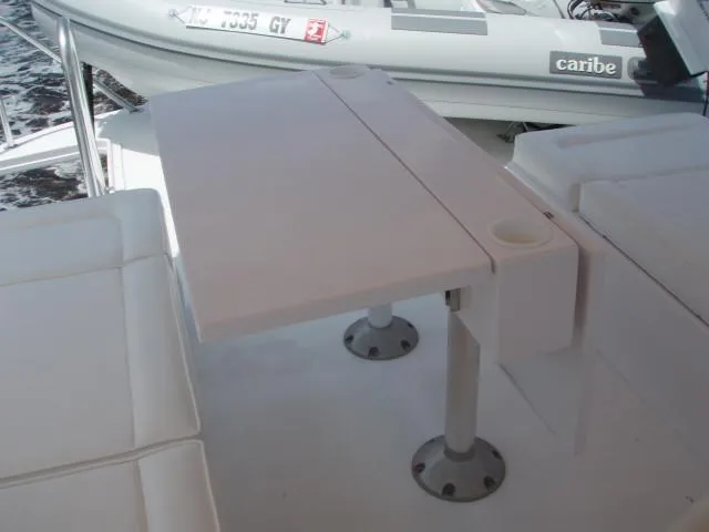 Slide: The Image of Great Harbour N40 2025 yacht interior with white seating and foldable table. - 18