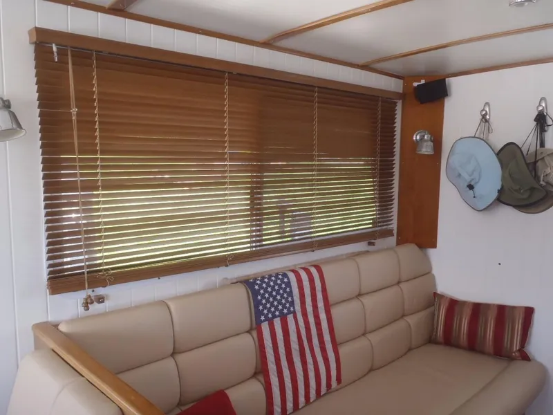 Slide: The Image of Interior of 2025 Great Harbour N40 with beige sofa, American flag, and wooden blinds. - 24