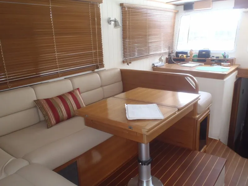 Slide: The Image of Interior of 2025 Great Harbour N40 yacht with beige seating and wooden table. - 28