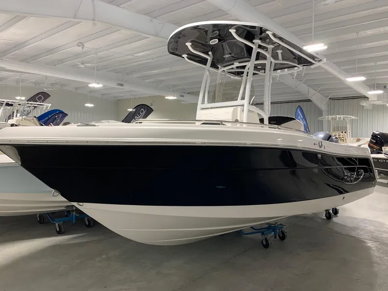 The Image of 2024 Robalo R222 Explorer boat in showroom, black and white hull, T-top roof. - 0