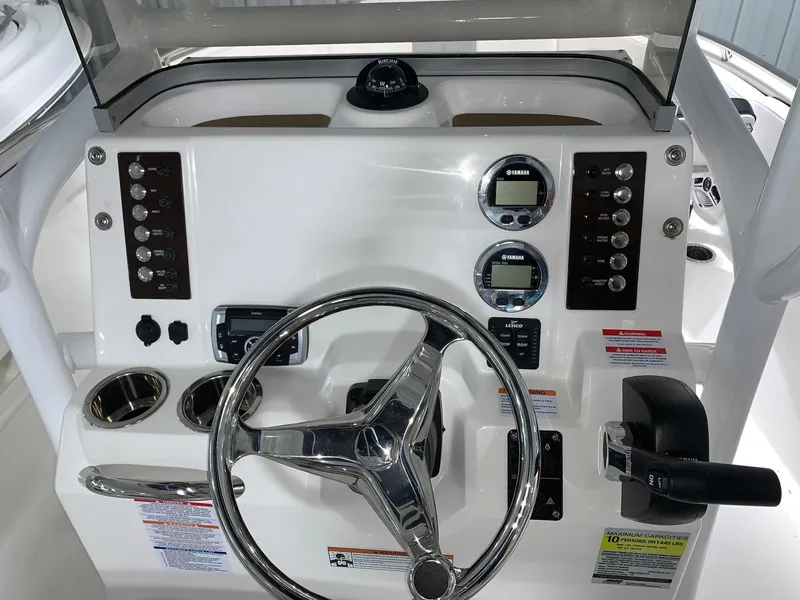 Slide: The Image of 2024 Robalo R222 Explorer boat dashboard with steering wheel and control panel. - 2