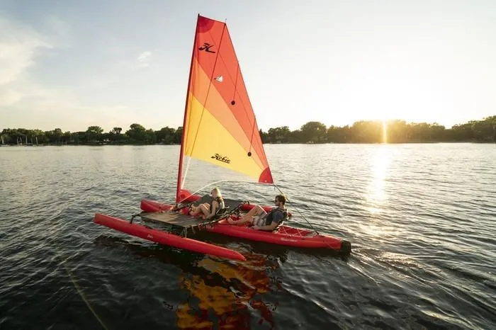Slide: The Image of 2023 Hobie Mirage Tandem Island sailing on a lake at sunset. - 0
