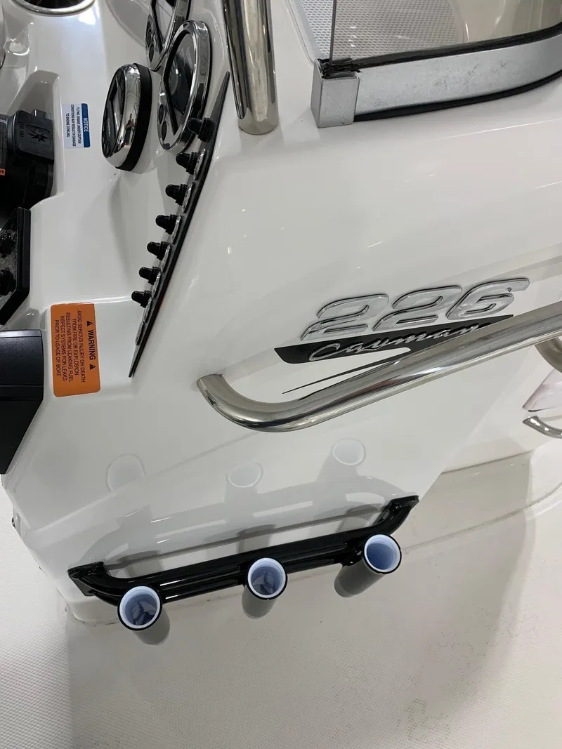 Slide: The Image of 2024 Robalo 226 Cayman boat console with rod holders and control panel. - 12