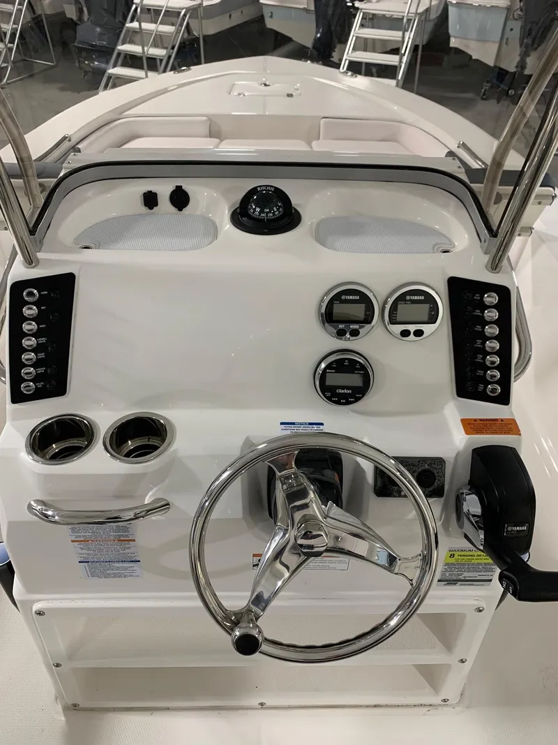 Slide: The Image of 2024 Robalo 226 Cayman boat dashboard with steering wheel and control panel. - 6