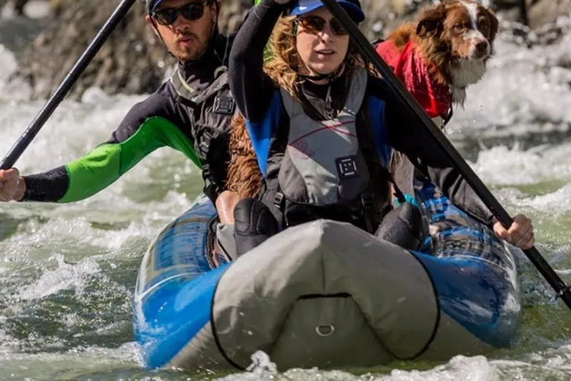Slide: The Image of People and dog kayaking in a 2022 TomCat Tandem inflatable kayak on a river. - 3