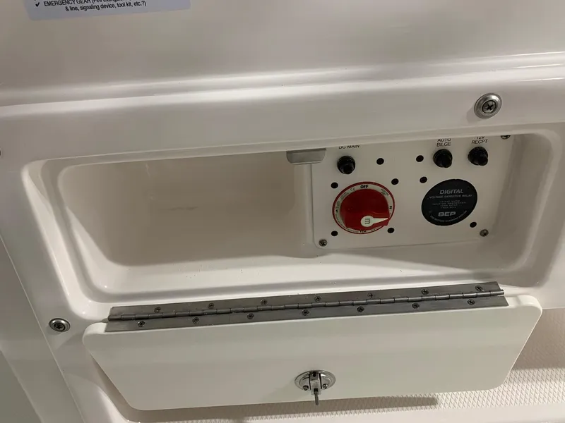Slide: The Image of Control panel of 2024 Robalo 246 Cayman boat with open compartment. - 11