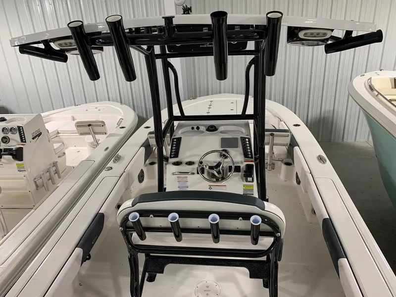 Slide: The Image of 2024 Robalo 246 Cayman center console boat with T-top and rod holders. - 2